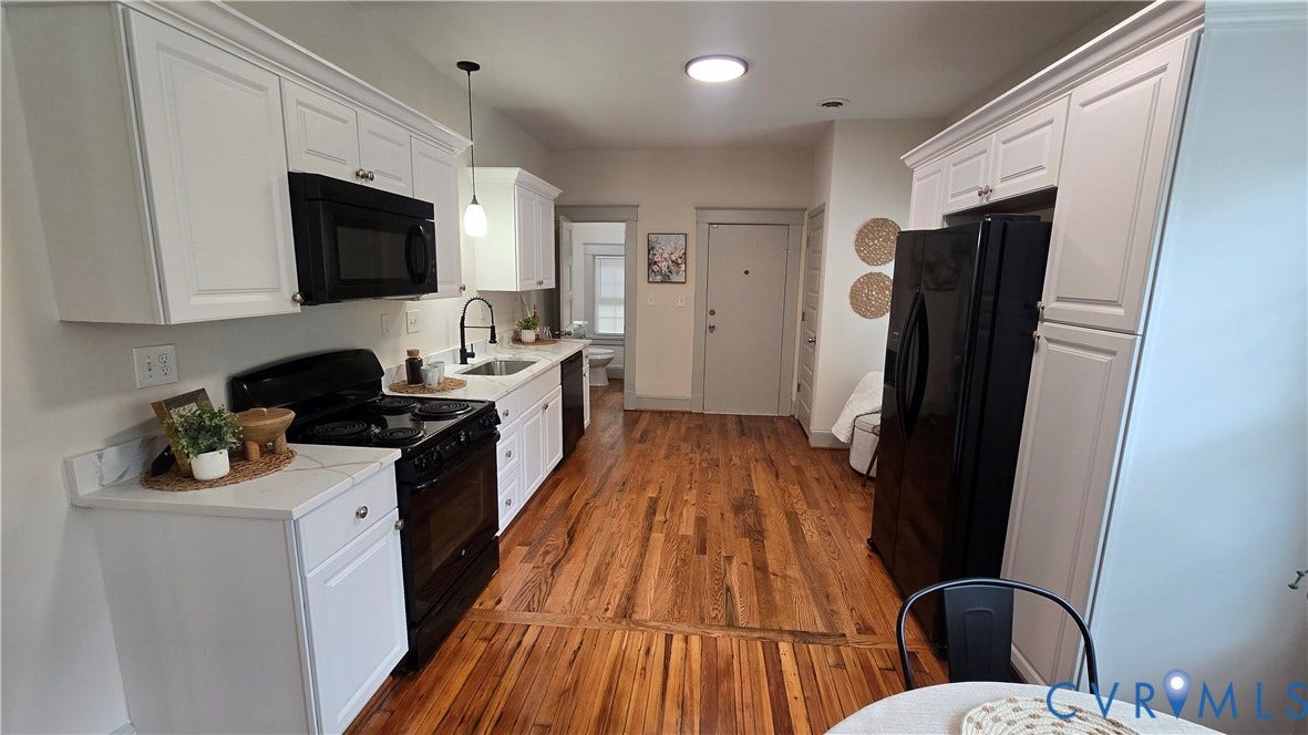 2317 5th Avenue, Richmond, VA 23222 White shaker cabinetry with crown molding, black appliances, light-toned countertops, wood-finish flooring, and pendant lighting