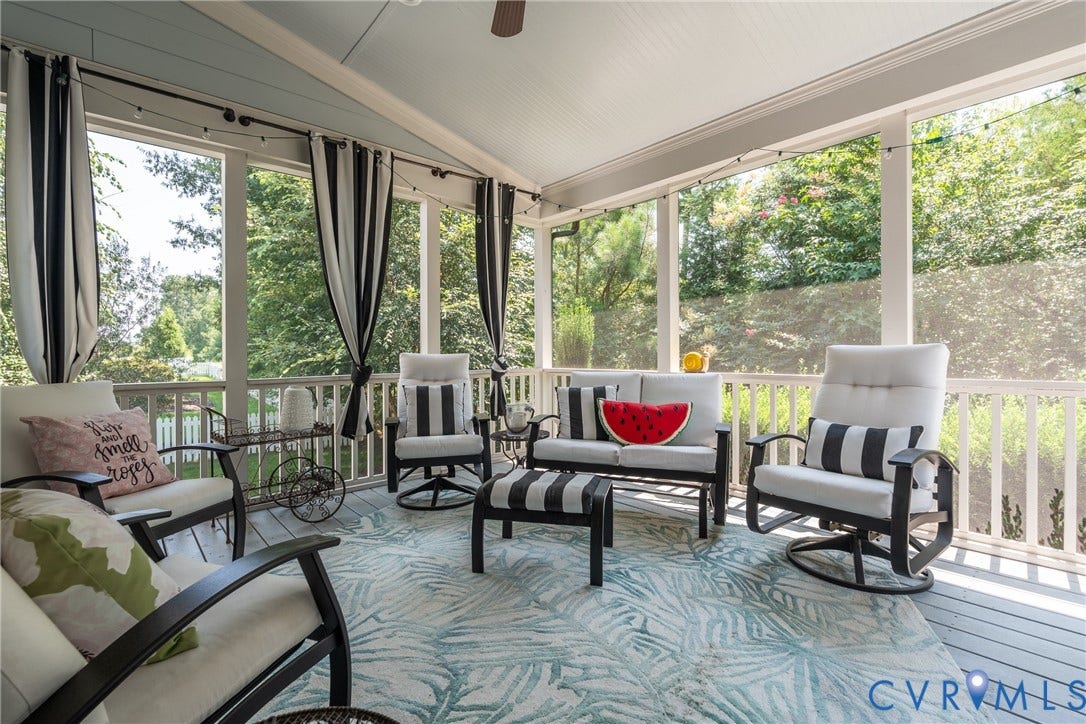 Screened porch with painted wood flooring and a sloped ceiling