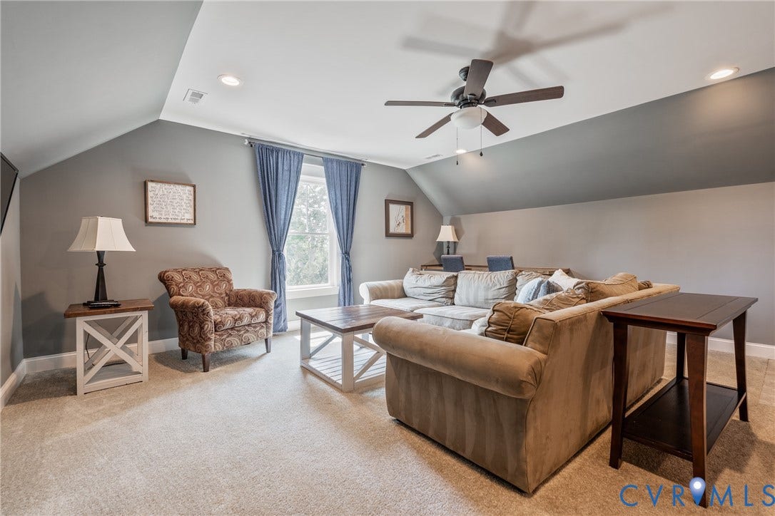 Carpeted room featuring a ceiling fan, recessed lighting, and a window with blue drapes