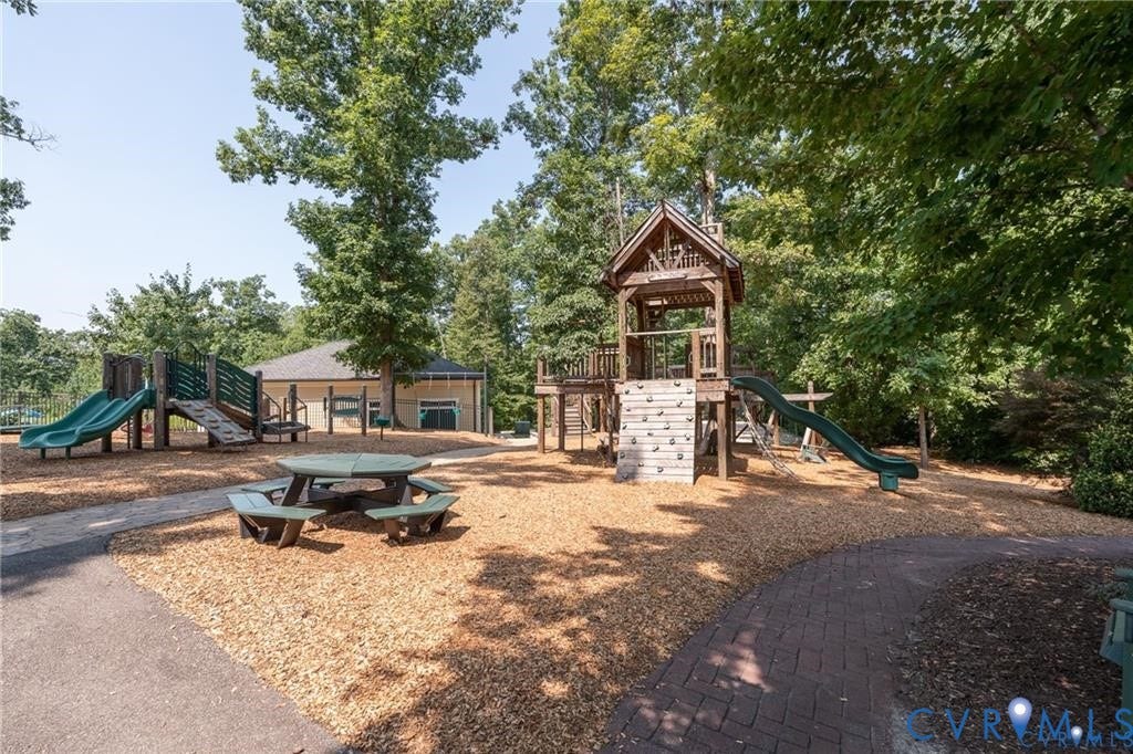 Outdoor play structure with multiple slides, climbing wall, and elevated platform