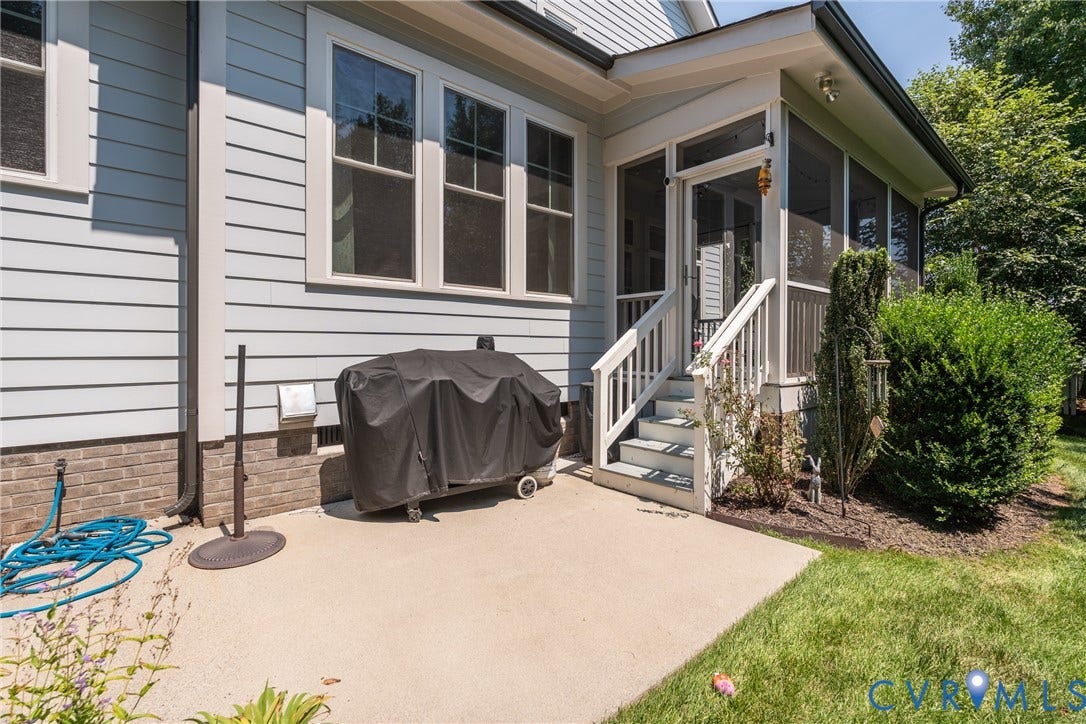 Concrete patio with a screened porch entry, white railings, and light blue siding