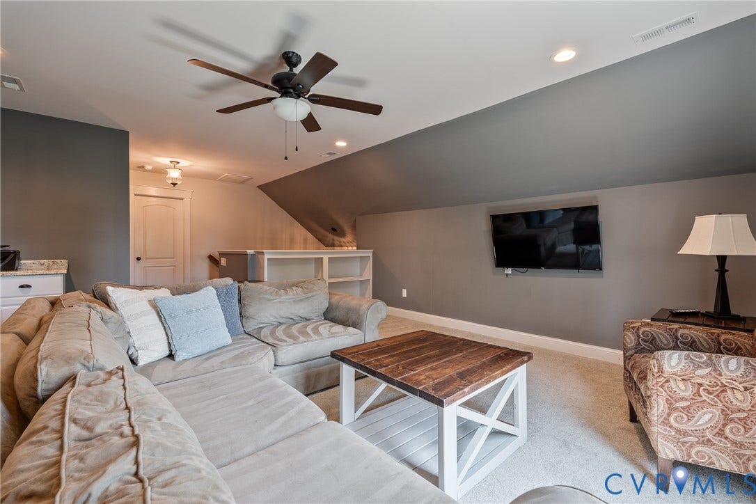 Carpeted bonus room with a ceiling fan, recessed lighting, and a built-in media shelf