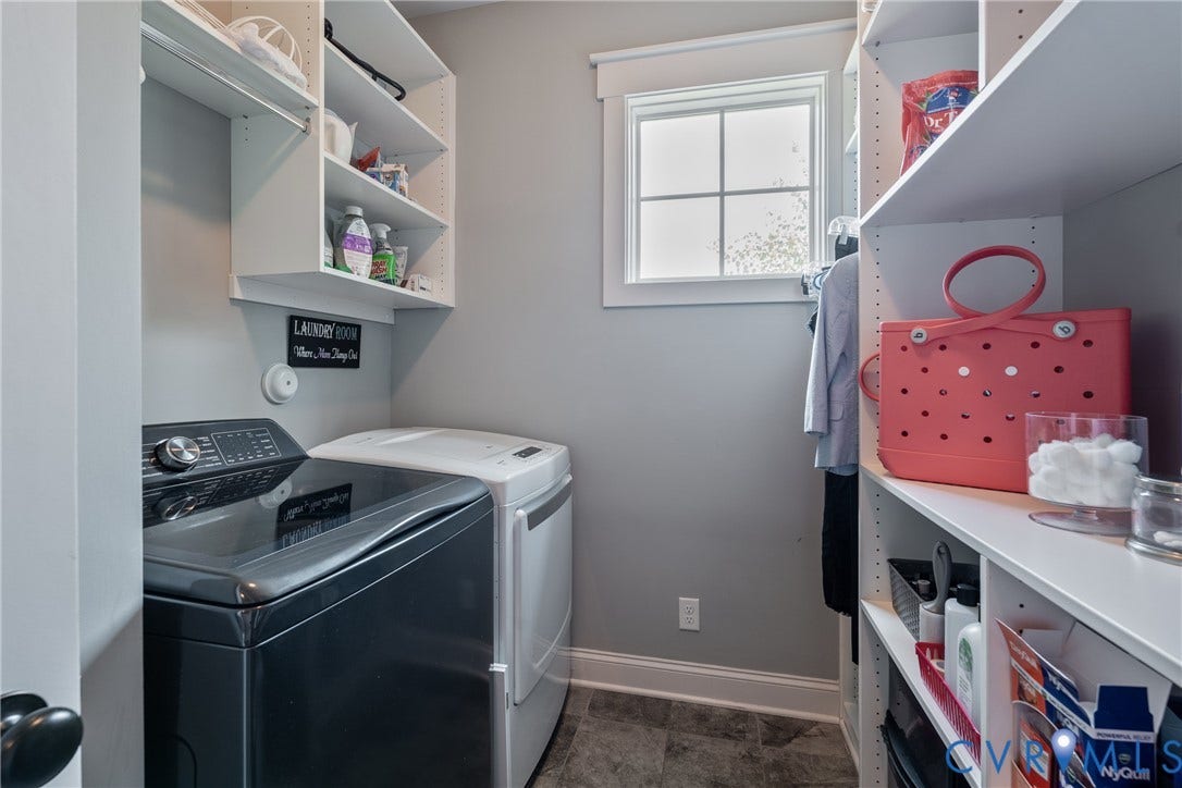 Dedicated utility space featuring built-in shelving, a window, and tile flooring