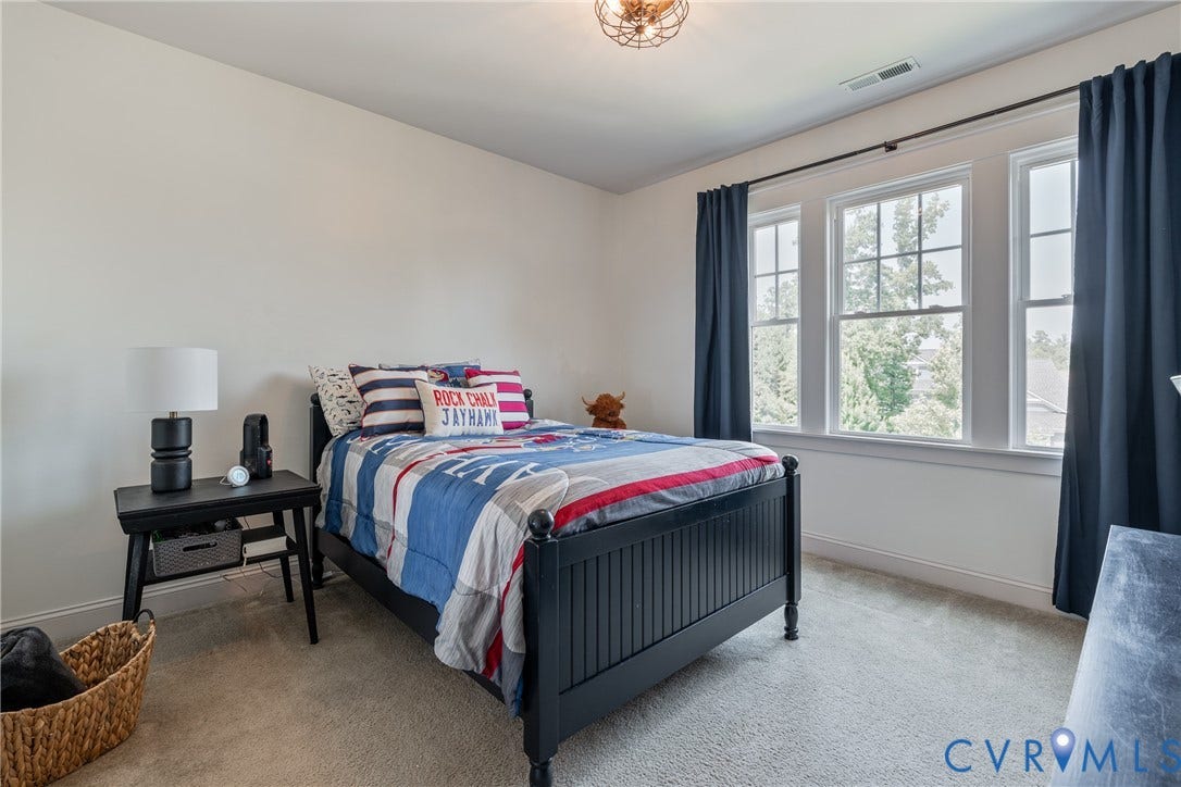 Carpeted flooring, white walls, triple pane windows, and a decorative ceiling light fixture