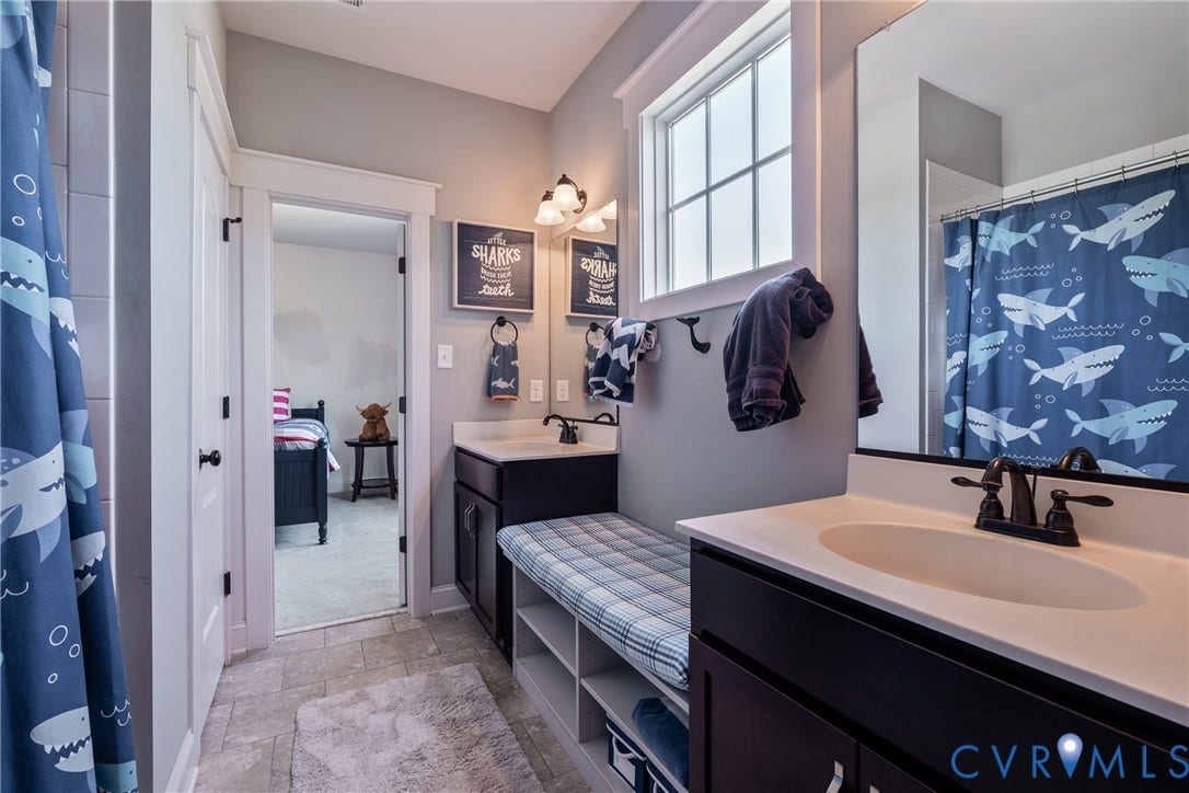 Dual vanity with integrated sinks, dark wood-finish cabinetry, and matte black fixtures