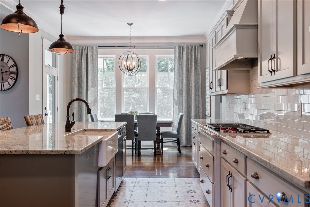 Kitchen featuring a farmhouse sink, granite countertops, subway tile backsplash, and a gas range