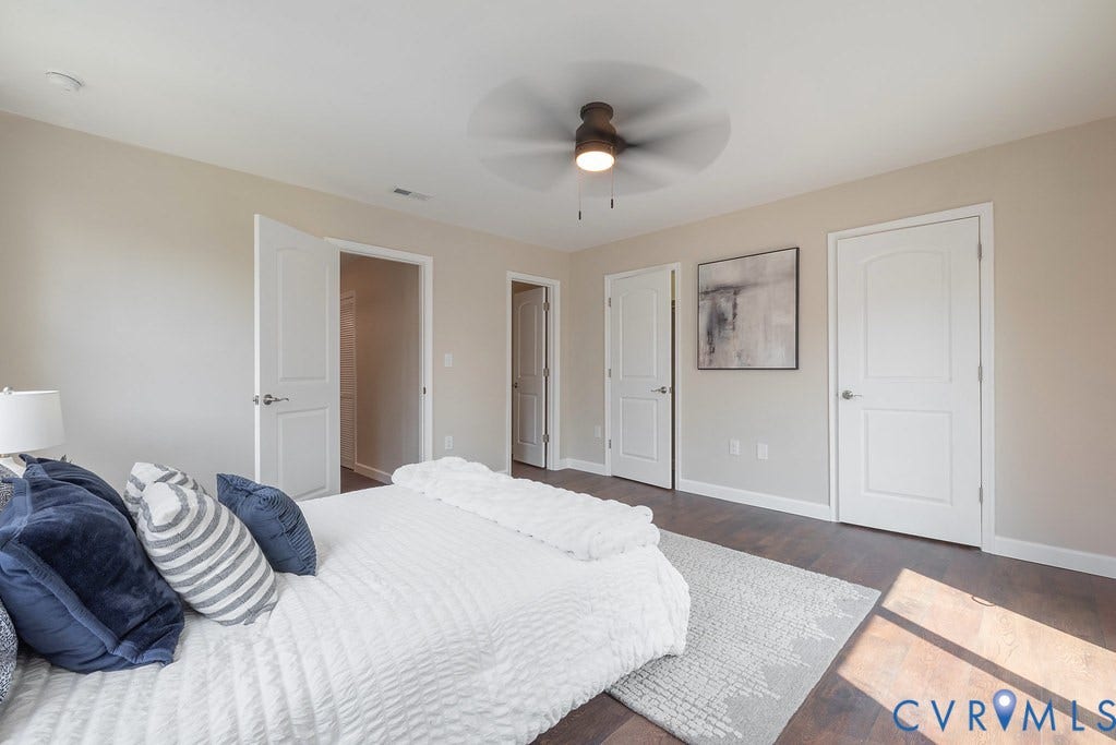 Wood-finish flooring with light-toned walls, white trim, and a ceiling fan with integrated lighting