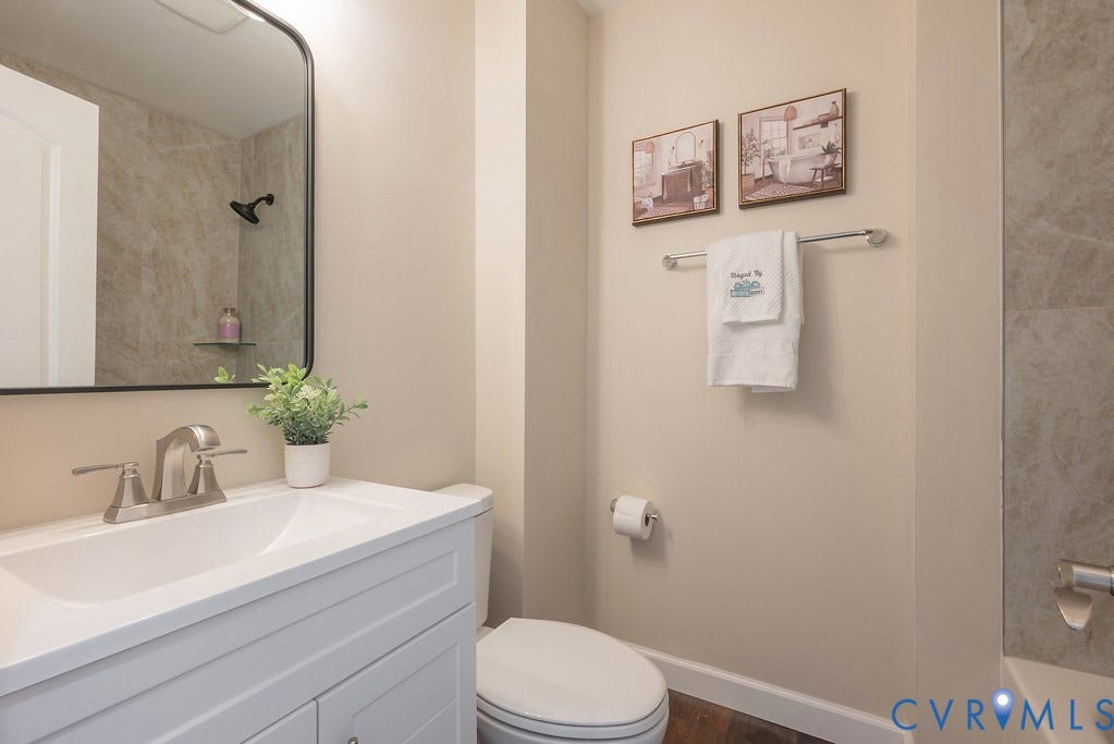 White vanity with a single basin sink and brushed nickel faucet
