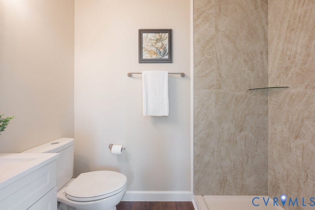 Floor-mounted toilet with a white vanity and integrated sink