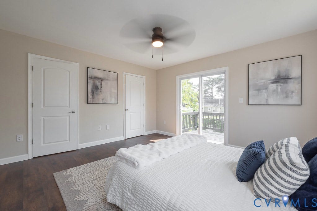 Wood-finish flooring with light-toned walls, white trim, and a ceiling fan