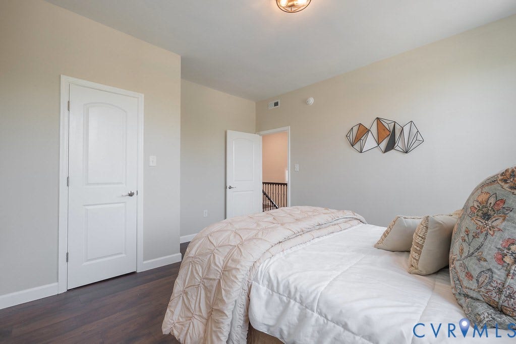 Wood-finish flooring, white paneled doors, and neutral wall tones