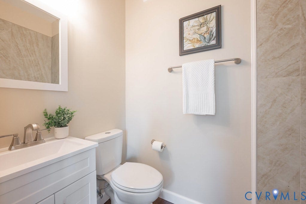 White vanity with integrated sink, brushed nickel faucet, and framed mirror