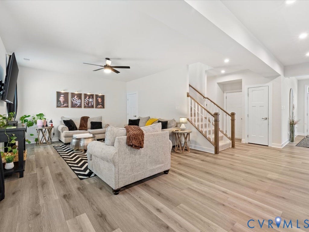 Open-concept living space featuring light wood-finish flooring, recessed lighting, and a ceiling fan