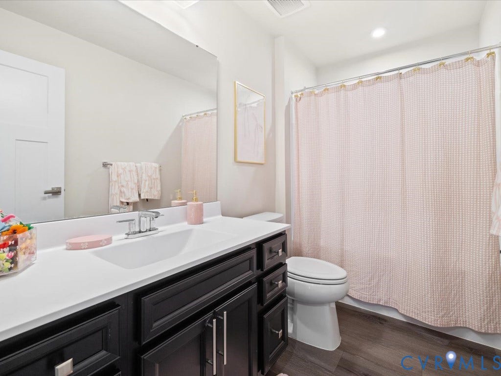 Bathroom featuring a vanity with dark wood-finish cabinetry, a white countertop, and an undermount sink