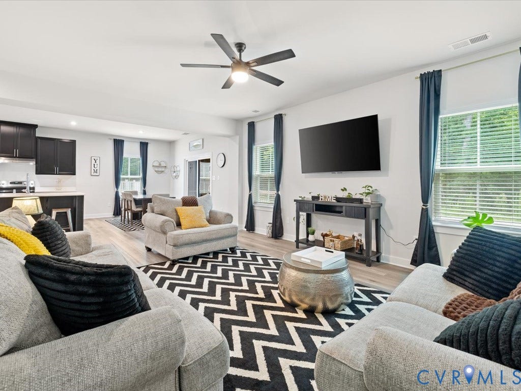 Open-concept living space with wood-finish flooring, a ceiling fan, and recessed lighting
