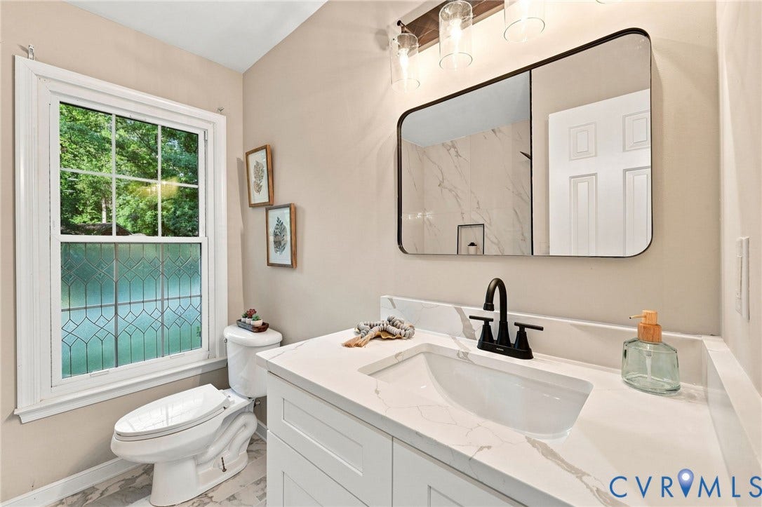 4106 Gloucestershire Street, North Chesterfield, VA 23236 White vanity with a quartz countertop and integrated sink, matte black faucet, and a contemporary wall mirror