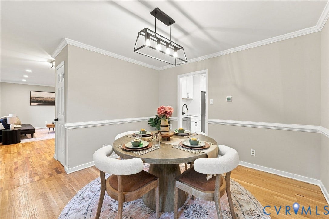 4106 Gloucestershire Street, North Chesterfield, VA 23236 Hardwood flooring with crown molding and chair rail detailing, complemented by a modern linear chandelier