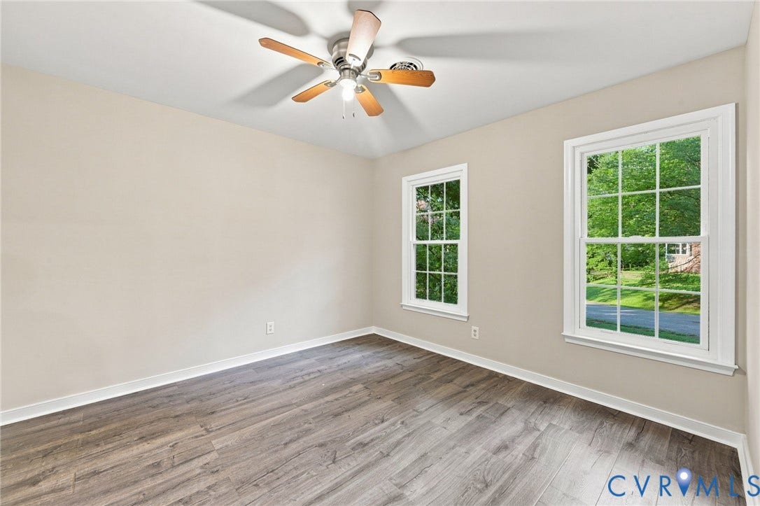 4106 Gloucestershire Street, North Chesterfield, VA 23236 Wood-finish flooring, two large windows, neutral wall paint, and a ceiling fan with integrated lighting