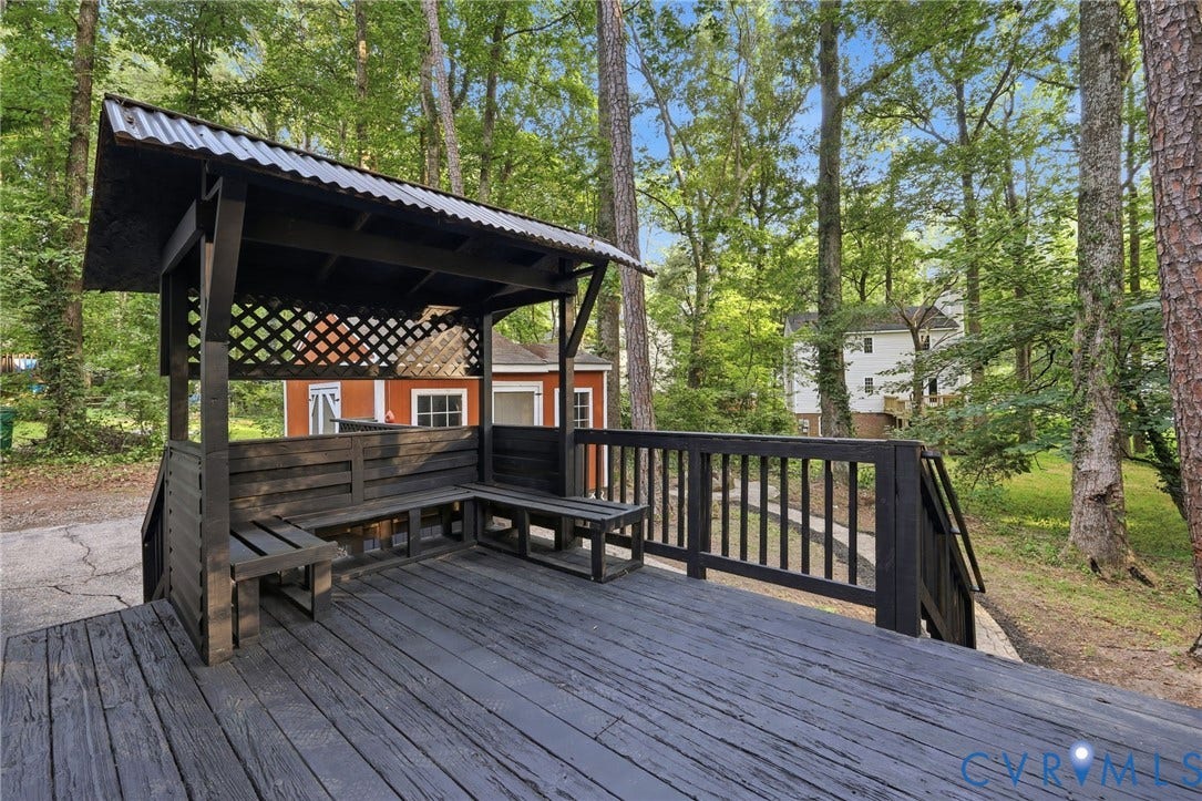 4106 Gloucestershire Street, North Chesterfield, VA 23236 Expansive outdoor deck featuring wood flooring, a built-in seating area with a lattice accent, and a covered section with a corrugated roof