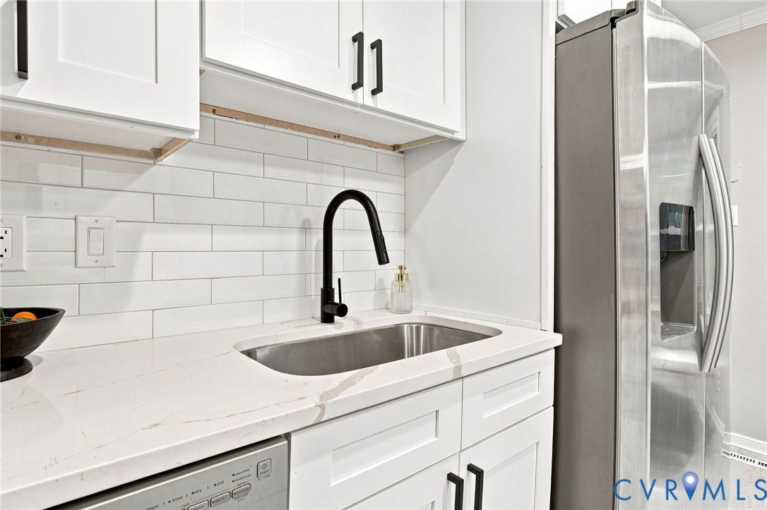 4106 Gloucestershire Street, North Chesterfield, VA 23236 White shaker-style cabinetry with matte black hardware, subway tile backsplash, stainless steel sink with matte black faucet, integrated stainless steel dishwasher, and a side-by-side stainless steel refrigerator