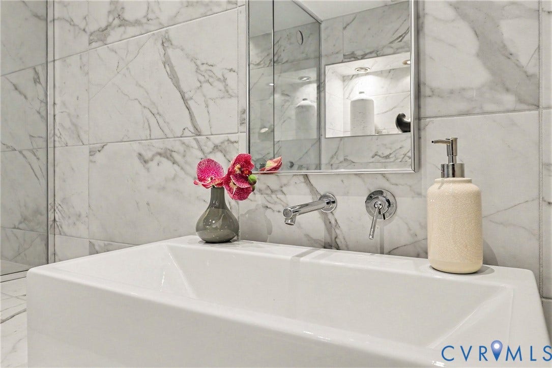 1101 Haxall Point, #U512 U510, Richmond, VA 23219 White rectangular vessel sink with chrome wall-mounted faucet, complemented by white marble-look tile walls