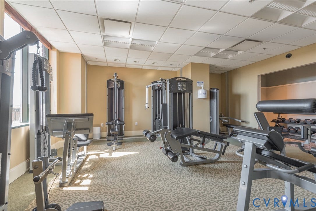 1101 Haxall Point, #U512 U510, Richmond, VA 23219 Fitness center with multiple weight machines, expansive windows, drop ceiling, and patterned carpet flooring