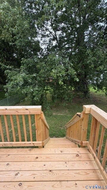 Newly constructed wooden deck featuring vertical spindle railings and expansive views of mature landscaping and established trees