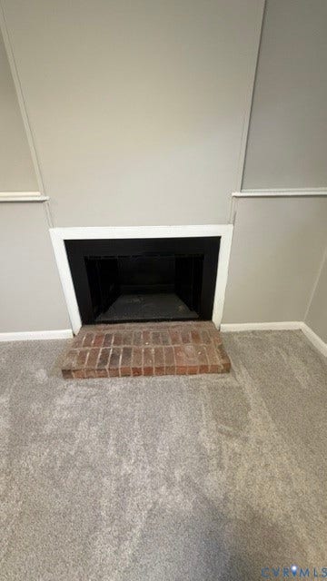Brick fireplace hearth with a dark firebox surround