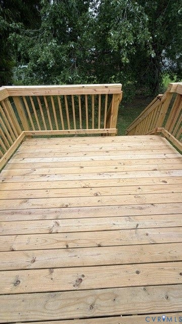 Expansive wood deck with a natural finish, featuring a full wood railing system and integrated wood stairs