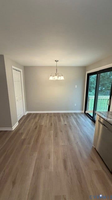 Wood-finish flooring, overhead chandelier, sliding glass door, and stainless steel appliance