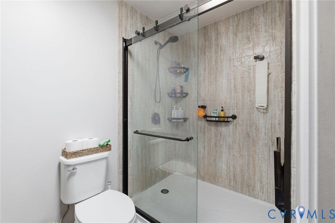 10744 Brookley Road, Glen Allen, VA 23060 Glass-enclosed shower with a sliding door and dark-finish hardware