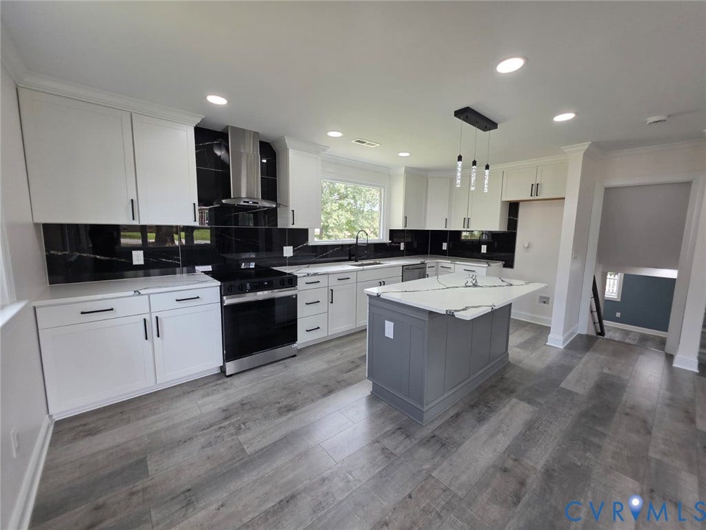16109 Meridian Avenue, Chester, VA 23831 Modern kitchen featuring white shaker cabinetry, stainless steel appliances, black tile backsplash, and a central island with a waterfall countertop
