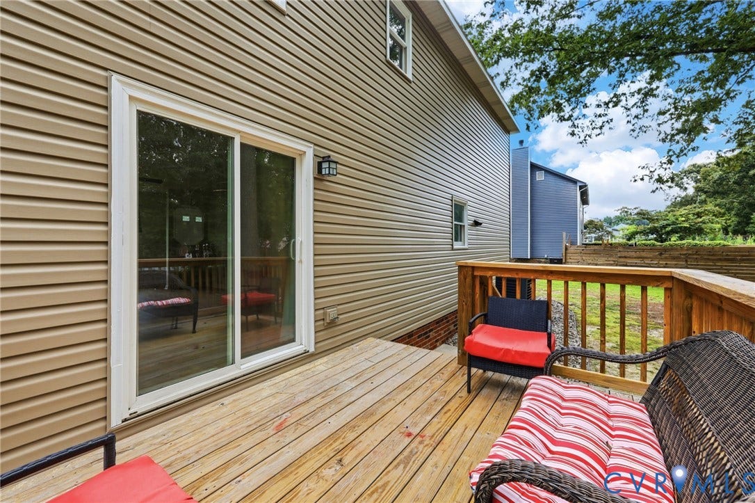 2807 Executive Drive, John Tyler Woods, Chesterfield, VA 23831 Spacious rear deck with wood railing, tan siding, and a white-framed sliding glass door