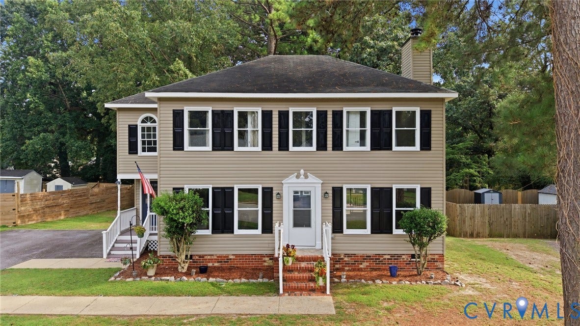 2807 Executive Drive, John Tyler Woods, Chesterfield, VA 23831 Two-story residence featuring light-toned siding, dark shutters, a front entry with brick-clad steps, and a side entrance with white railings