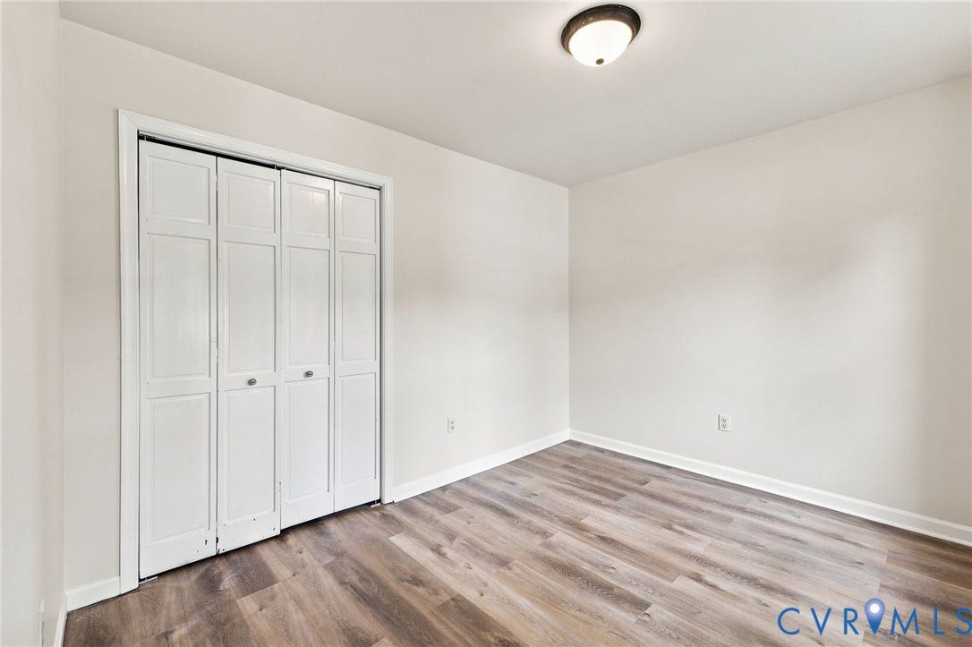 2807 Executive Drive, John Tyler Woods, Chesterfield, VA 23831 Crisp white walls, wood-finish flooring, white bi-fold closet doors, and a ceiling-mounted light fixture