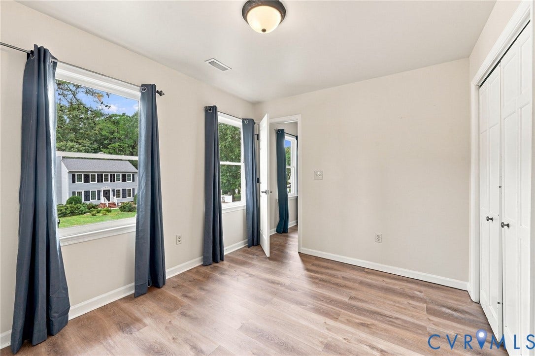 2807 Executive Drive, John Tyler Woods, Chesterfield, VA 23831 Spacious room featuring wood-finish flooring, multiple windows, a ceiling-mounted light fixture, and a bi-fold closet