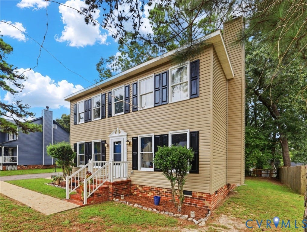 2807 Executive Drive, John Tyler Woods, Chesterfield, VA 23831 Two-story residence featuring light-colored siding, multiple windows with dark shutters, a front entry with a small porch, and a side chimney