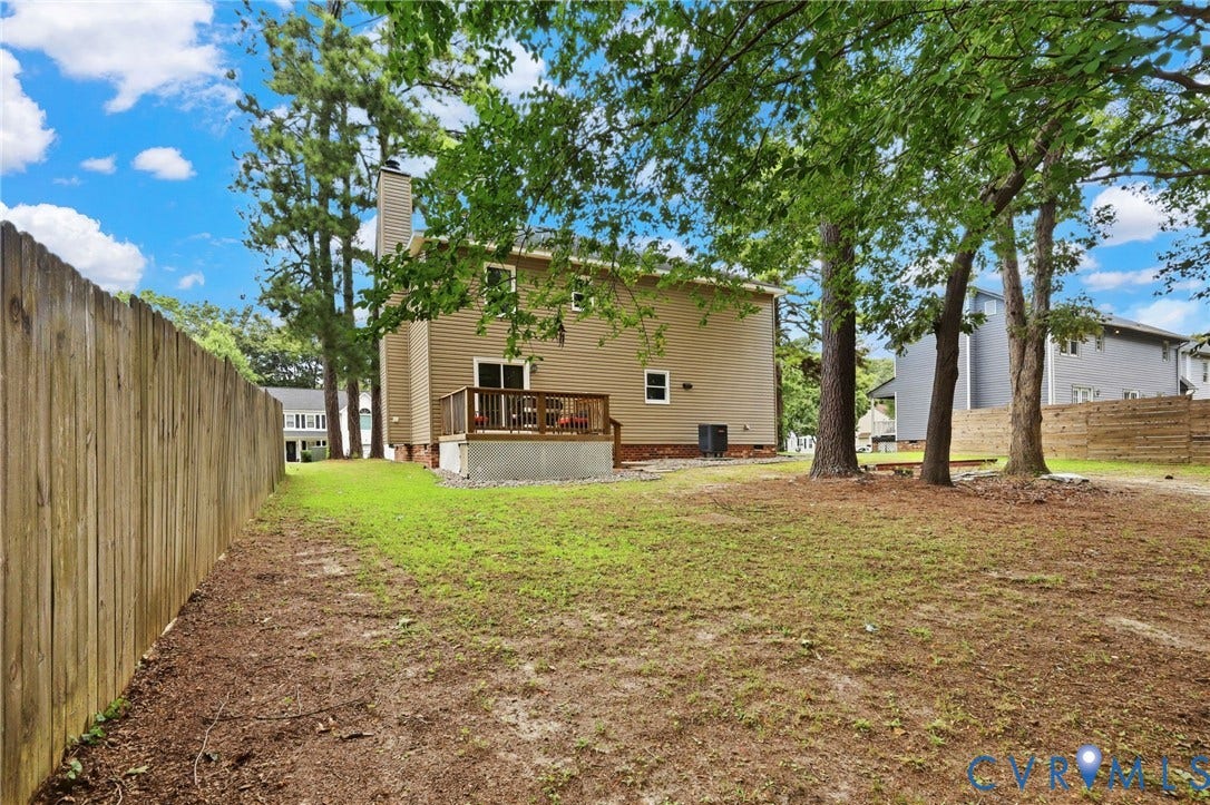 2807 Executive Drive, John Tyler Woods, Chesterfield, VA 23831 Expansive backyard featuring a wood privacy fence, mature trees, and a raised wood deck with railing