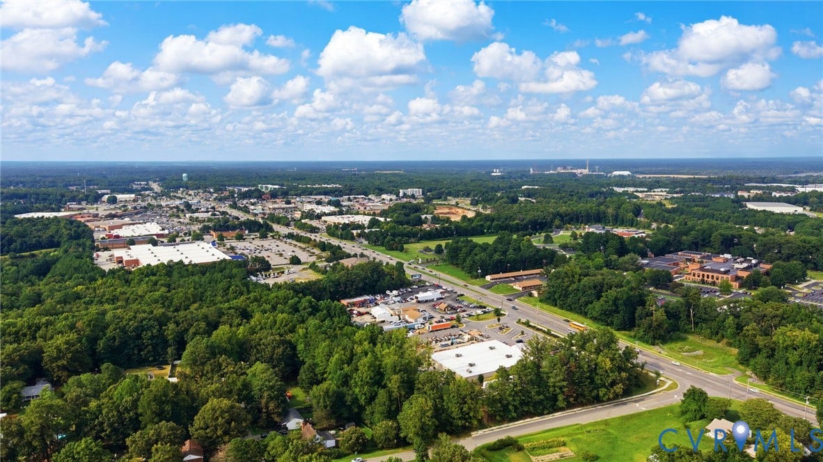2807 Executive Drive, John Tyler Woods, Chesterfield, VA 23831 Expansive aerial perspective showcasing a developed suburban area with abundant mature trees, multiple commercial structures, and a prominent roadway network