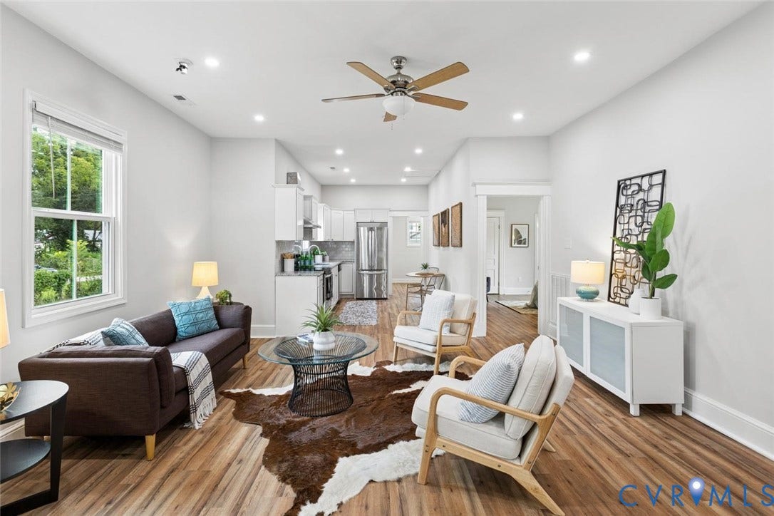 Open-concept living area with wood-finish flooring, recessed lighting, and a ceiling fan