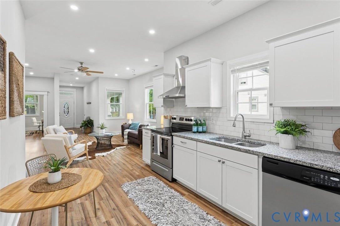Kitchen featuring white shaker cabinetry, speckled countertops, subway tile backsplash, and stainless steel appliances
