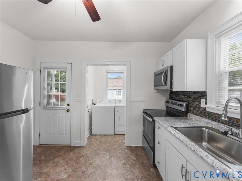 Kitchen featuring white cabinetry, a stainless steel sink, a dark tiled backsplash, and light speckled countertops