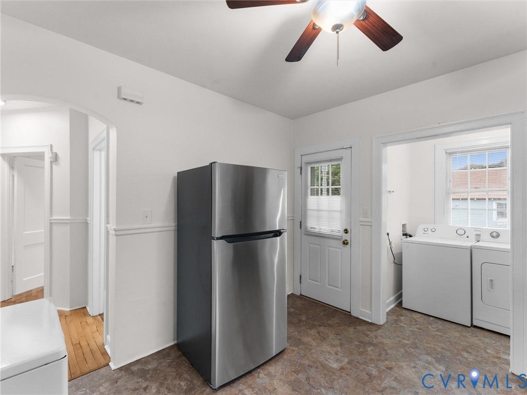 Functional utility space featuring a stainless steel refrigerator, ceiling fan, and vinyl flooring
