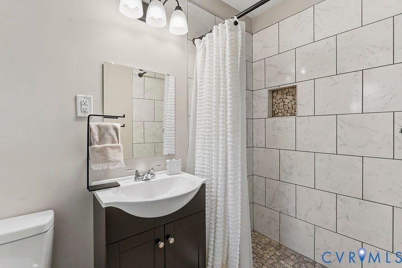 2016 Wrens Nest Road, Settlers Landing, Richmond, VA 23235 Walk-in shower with white tiled walls and mosaic pebble flooring