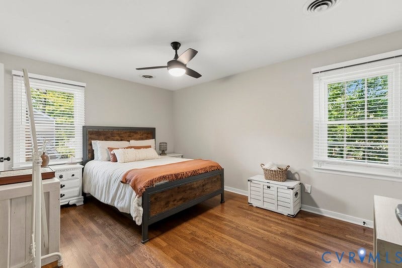 2016 Wrens Nest Road, Settlers Landing, Richmond, VA 23235 2nd Primary Suite Upstairs. Hardwood flooring, light gray wall paint, two windows with blinds, a ceiling fan, and white trim