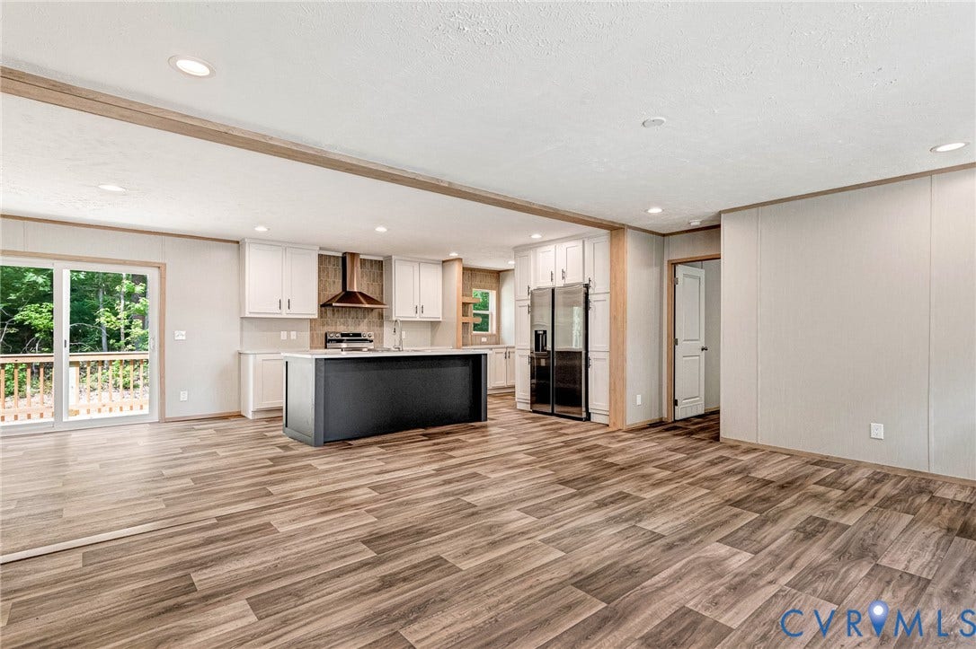 15263 Cross County Road, Mineral, VA 23117 Open-concept living space featuring wood-finish flooring, recessed lighting, and a kitchen with white cabinetry, a dark island, and stainless steel appliances