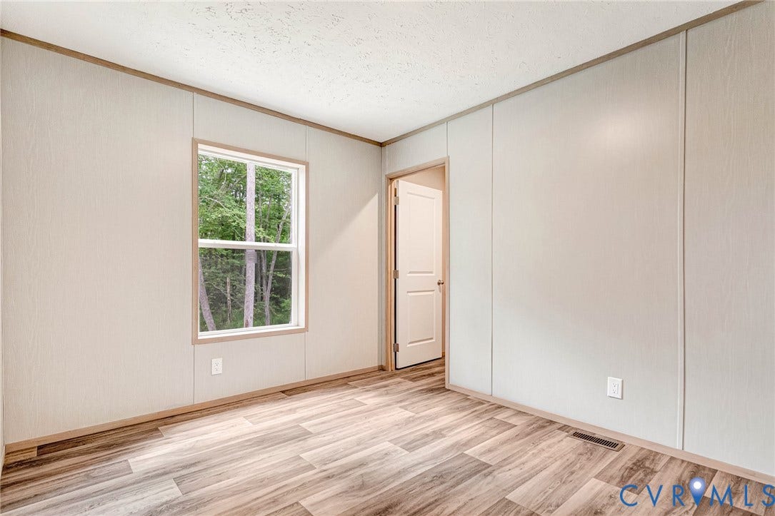 15263 Cross County Road, Mineral, VA 23117 Wood-finish flooring, white panel wall finishes, and a single window with white trim