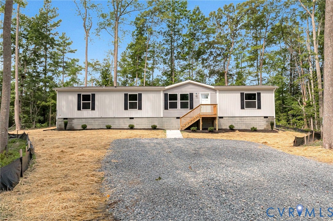 15263 Cross County Road, Mineral, VA 23117 Light gray siding exterior with black window shutters, elevated entry with wood stairs, and a gravel driveway