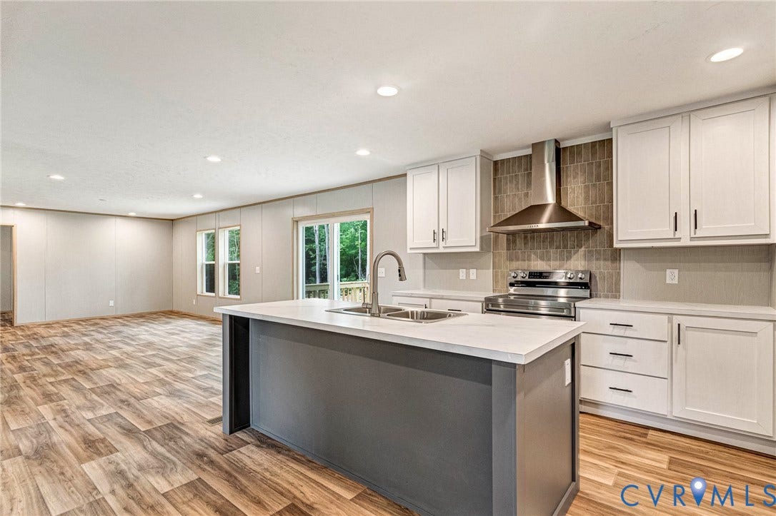 15263 Cross County Road, Mineral, VA 23117 Kitchen featuring a central island with an integrated sink, stainless steel range, and a tiled backsplash