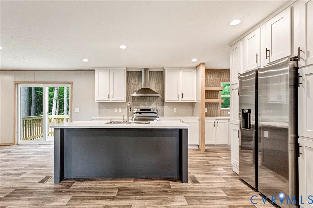15263 Cross County Road, Mineral, VA 23117 Open-concept kitchen featuring an island with a built-in sink, white cabinetry, stainless steel appliances, and wood-finish flooring